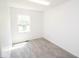 Bright bedroom features a window, neutral carpet, and freshly painted white walls at 233 N Fenton Ave, Indianapolis, IN 46219