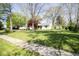 Traditional home set on a spacious lawn with mature trees and a paved sidewalk at 233 N Fenton Ave, Indianapolis, IN 46219