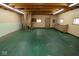 Spacious garage interior with a wooden staircase, built-in cabinets, and an open ceiling structure at 233 N Fenton Ave, Indianapolis, IN 46219