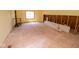 Renovation-ready room showcases exposed framing, a window, and a plywood floor, offering a blank canvas at 233 N Fenton Ave, Indianapolis, IN 46219