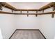 Spacious walk-in closet with custom wood shelving and neutral carpeting at 233 N Fenton Ave, Indianapolis, IN 46219