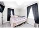 A cozy bedroom featuring a pink bedspread, plush pillows, and a sunny window for natural light at 2333 Calhoun St, Indianapolis, IN 46203