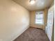 A small bedroom with carpet, a window, and a door to another room at 274 Leeds Ave, Indianapolis, IN 46201