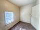 This is a simple bedroom with carpet floors, a window with blinds and a door at 274 Leeds Ave, Indianapolis, IN 46201