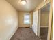 A small bedroom with carpet, a window, and a door to another room at 274 Leeds Ave, Indianapolis, IN 46201