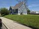 Exterior side view of home with blue siding, white trim, grass lawn, and paved sidewalk at 2819 W 16Th St, Indianapolis, IN 46222