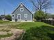 Exterior side view of home with blue siding, white trim, grass lawn, and concrete perimeter at 2819 W 16Th St, Indianapolis, IN 46222