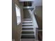 Stairway bathed in light features a large window and newly painted steps at 2819 W 16Th St, Indianapolis, IN 46222