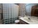 Full bathroom featuring single sink vanity, bathtub with shower, and floral wallpaper at 3427 Brunswick Ave, Indianapolis, IN 46227