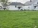 Backyard with green grass leading to a house with a covered porch and seating area at 3434 Forrest Ter, Anderson SE, IN 46013