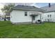 View of a home's backyard with a small covered porch with chairs and a grill at 3434 Forrest Ter, Anderson SE, IN 46013