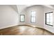 Spacious bedroom featuring hardwood floors, white walls, and three windows at 3868 N Park Ave, Indianapolis, IN 46205