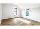 Bright bedroom with hardwood floors, neutral walls, and two windows at 3868 N Park Ave, Indianapolis, IN 46205