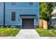 View of the garage of a beautiful blue two-story house with a well-kept lawn on a sunny day at 3868 N Park Ave, Indianapolis, IN 46205