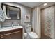 Bright bathroom featuring a vanity, mirror, toilet, and tiled shower with curtain at 4000 N Meridian St # Apt 15J, Indianapolis, IN 46208