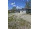Detached garage, gray siding, gravel driveway and blue sky with scattered clouds at 4006 Kenneth Ave, Indianapolis, IN 46226