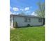 Side view of home, gray siding, dark trim, lawn with weeds, blue sky with scattered clouds at 4006 Kenneth Ave, Indianapolis, IN 46226