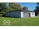 Detached garage with gray siding and gray garage door, green lawn at 4006 Kenneth Ave, Indianapolis, IN 46226