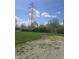 Utility pylon and overgrown lawn with weeds, blue sky with scattered clouds at 4006 Kenneth Ave, Indianapolis, IN 46226