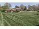 Expansive backyard featuring a lush lawn, mature trees, and a brick house with a covered patio at 4037 Hazy Ln, Greenwood, IN 46142