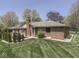 Brick house backyard featuring mature trees, a covered patio and manicured lawn at 4037 Hazy Ln, Greenwood, IN 46142