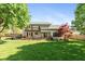 Expansive backyard with a well-maintained lawn, wooden deck, and mature trees at 4651 Monterey Dr, Columbus, IN 47203