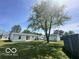 Expansive backyard featuring a well-maintained lawn, mature trees, and a glimpse of the white home at 4726 Breckenridge Dr, Columbus, IN 47203