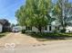 Charming single-story home with mature trees, green lawn, and a white car in the driveway, offering classic appeal at 4726 Breckenridge Dr, Columbus, IN 47203