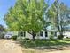 Traditional single-story house featuring mature trees, a well-maintained lawn, and a driveway with a white car at 4726 Breckenridge Dr, Columbus, IN 47203