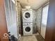Practical laundry room with a stacked washer and dryer, utility accessories, and a door to the outside at 4726 Breckenridge Dr, Columbus, IN 47203