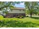 Expansive backyard features a wooden deck, well-maintained lawn, and mature trees for privacy at 500 Meadowlark Ct, Whiteland, IN 46184