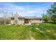 Backyard featuring a stone patio, covered porch, and expansive green lawn at 5079 S Lick Creek Rd, Morgantown, IN 46160