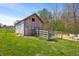 Rustic barn with a metal gate, wooden fences, and grazing animals in a serene setting at 5079 S Lick Creek Rd, Morgantown, IN 46160