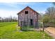 Rustic barn with weathered wood, metal gates, and a lush green field at 5079 S Lick Creek Rd, Morgantown, IN 46160