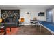 Basement living area with dark sectional couch, ping pong table, and hardwood floors at 5252 N College Ave, Indianapolis, IN 46220