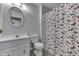 Well-lit bathroom featuring a decorative mirror, white vanity, and a festive holiday-themed shower curtain at 5335 Honey Comb Ln, Indianapolis, IN 46221