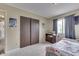 A well-lit bedroom featuring a window with curtains, sliding closet doors, and neutral decor at 5335 Honey Comb Ln, Indianapolis, IN 46221