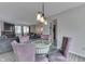 Dining area with a glass-top table, upholstered chairs, and views of the living room at 5335 Honey Comb Ln, Indianapolis, IN 46221