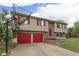Home exterior with red garage doors, red shutters, and a basketball hoop in the driveway at 5335 Honey Comb Ln, Indianapolis, IN 46221