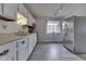 Bright kitchen featuring white cabinets, stainless steel appliances, and a view of the backyard at 5335 Honey Comb Ln, Indianapolis, IN 46221