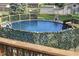 Above ground pool area surrounded by a decorative green privacy fence at 5335 Honey Comb Ln, Indianapolis, IN 46221