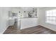 Bright living room with hardwood floors, modern pendant lighting, and open view to the kitchen at 5622 Imperial Woods Cir, Indianapolis, IN 46224