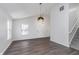 Bright living room with hardwood floors, modern pendant lighting, and staircase at 5622 Imperial Woods Cir, Indianapolis, IN 46224