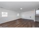 Open-concept living room with wood-look flooring and stairs leading to the second floor at 5622 Imperial Woods Cir, Indianapolis, IN 46224