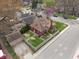 Aerial view features the property with a detached garage, fenced backyard, and a tree-lined street at 5697 Broadway St, Indianapolis, IN 46220