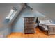 Attic bedroom with wooden floors, exposed beams, and natural light from the skylight at 5697 Broadway St, Indianapolis, IN 46220