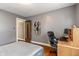 This bedroom has grey walls, wood floors, a desk, and an ensuite doorway offering convenience at 5697 Broadway St, Indianapolis, IN 46220