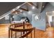 Attic bedroom with wooden floors, spiral staircase, exposed beams, and an en-suite bathroom at 5697 Broadway St, Indianapolis, IN 46220