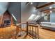 Bedroom with wooden floors, spiral staircase, exposed beams, skylights, and brick accent wall at 5697 Broadway St, Indianapolis, IN 46220