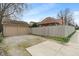 A detached two-car garage with a gravel driveway and partial view of the fenced backyard at 5697 Broadway St, Indianapolis, IN 46220